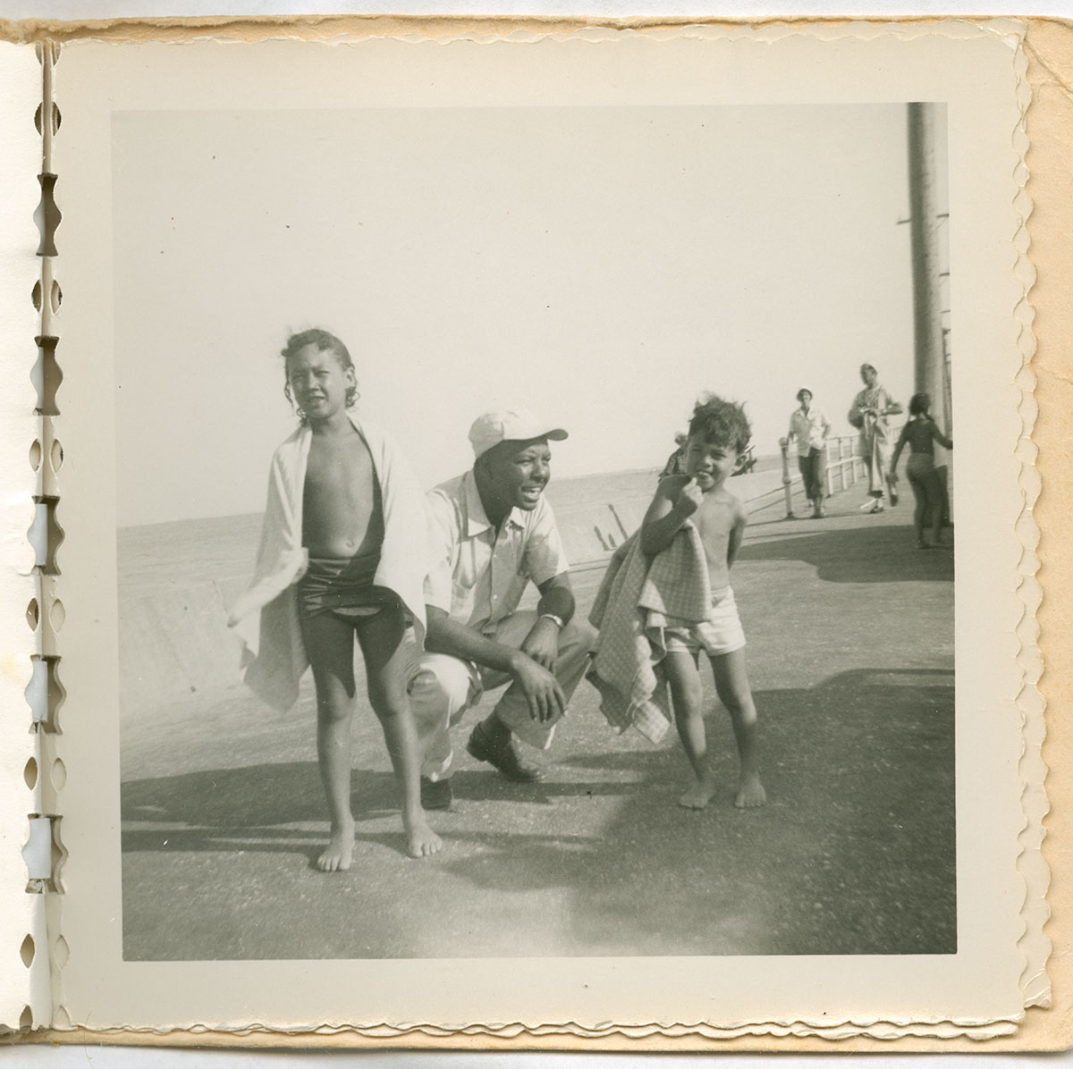 A man and two children standing by the beach