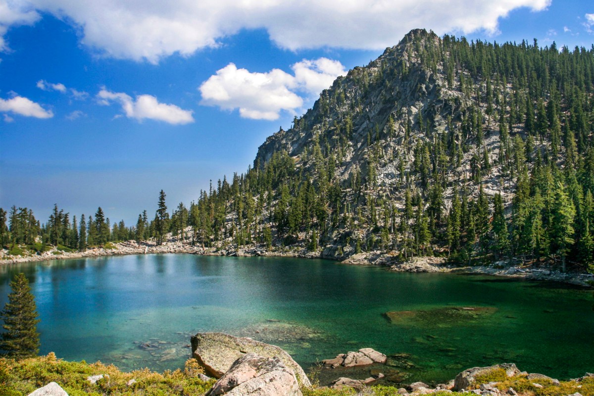 Photo of a lake with a rugged landscape in the background.