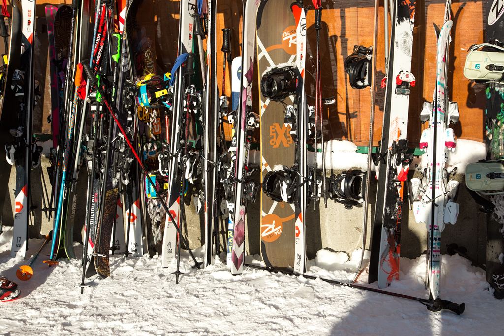 a rack full of skis and snowboards