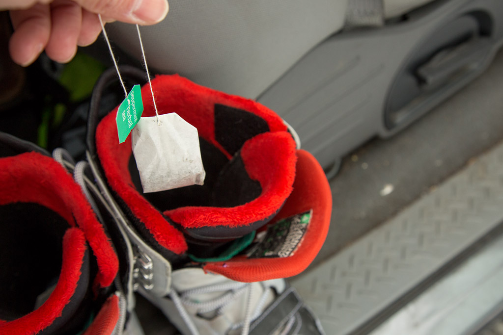 skier inserting a tea bag into ski boots to keep the funky smell at bay