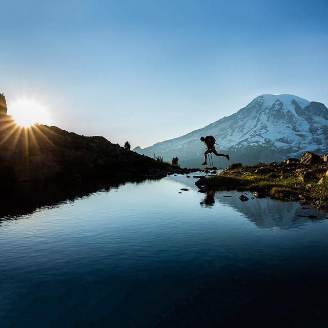 hiker jumps over water