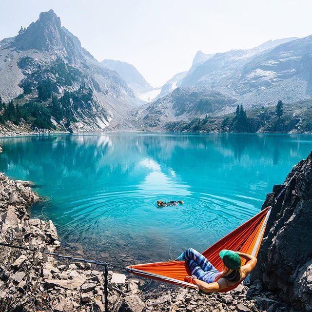 hammock near glacier lake with person swimming