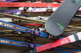 a pile of old skis and snowboards