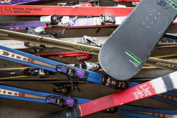 a pile of old skis and snowboards