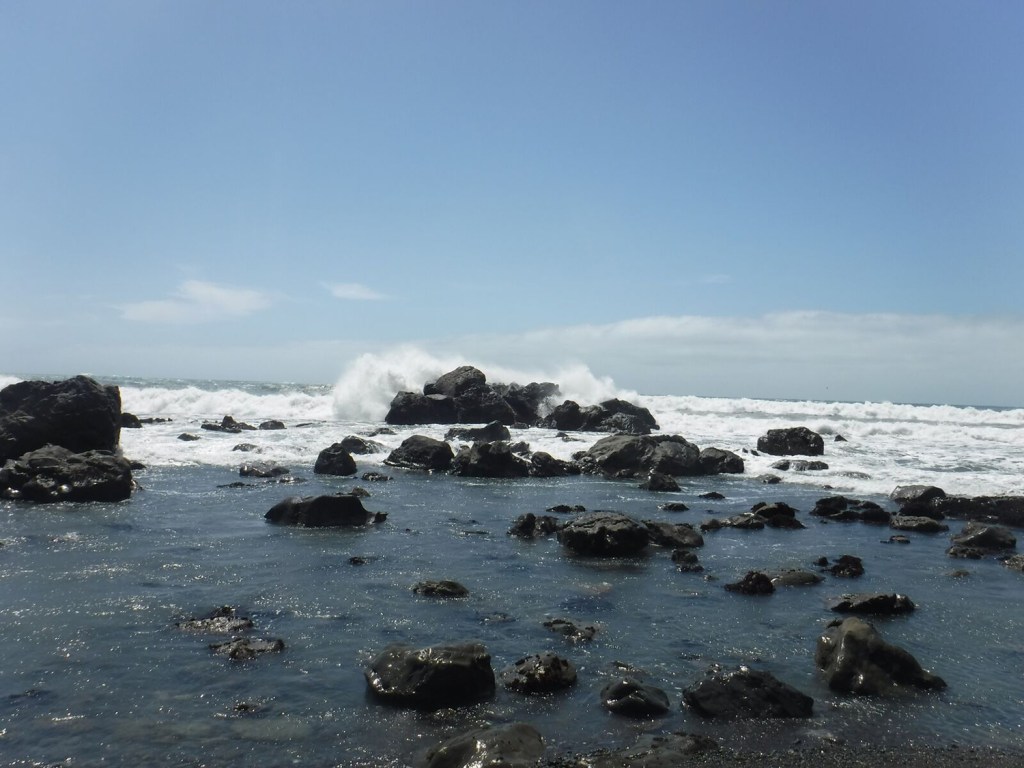 waves crashing onto a rocky beach coast