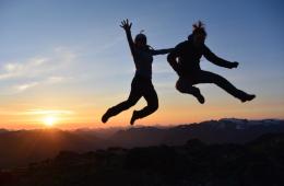 two girls jumping at sunset