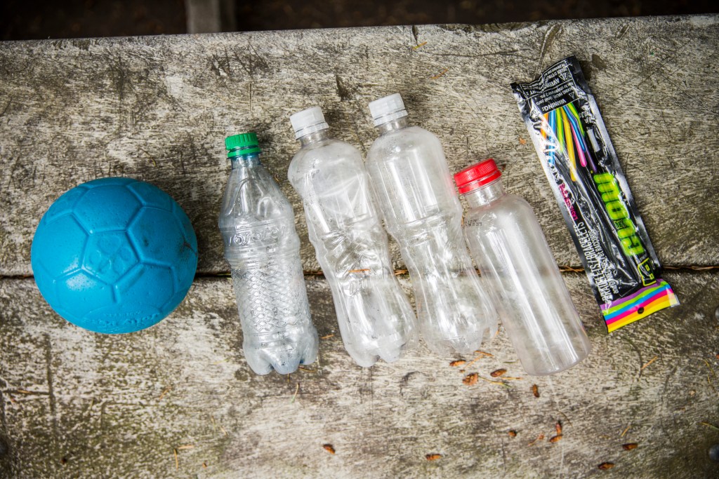 Soccer ball, water bottles and glow sticks used for midnight bowling