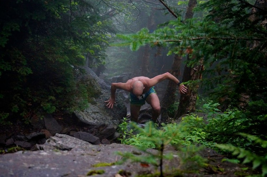 a man runs up a steep rocky trail