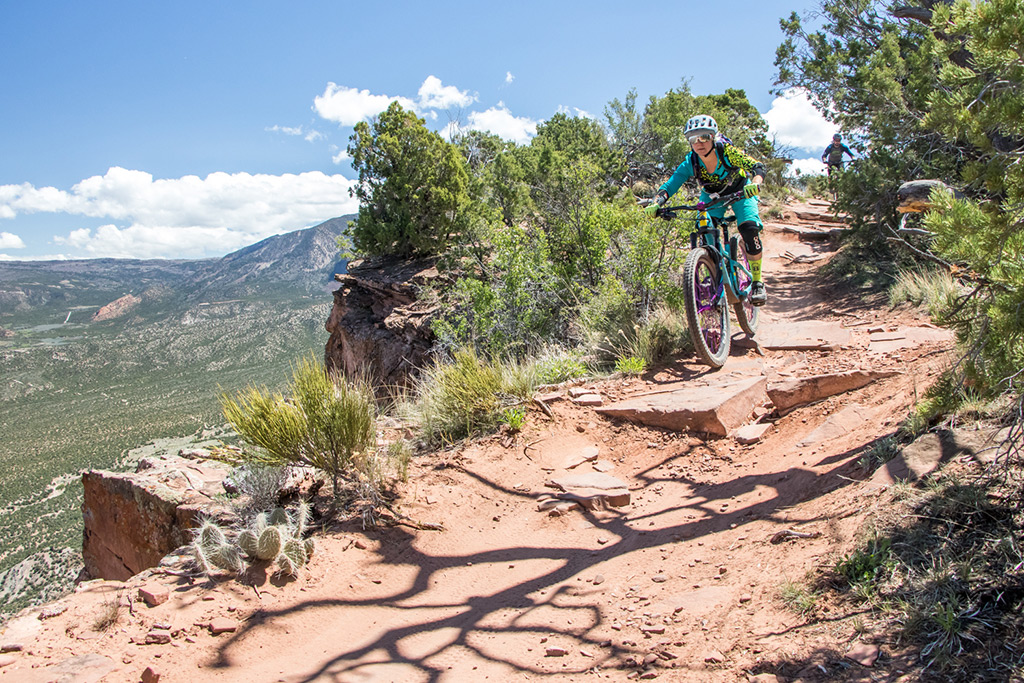 a rider descends ledgy terrain