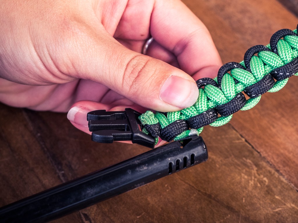 Paracord strand end with a lighter after gluing melted chord down