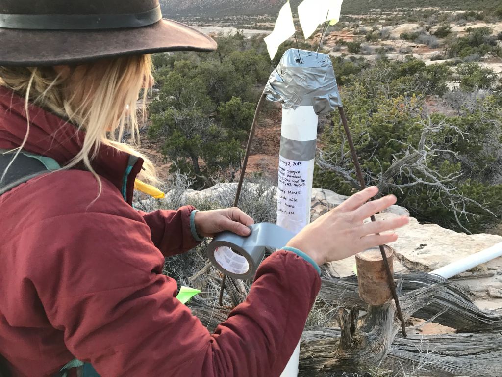 Morgan tapes their notice of location to the monument at the center of the mining claim.