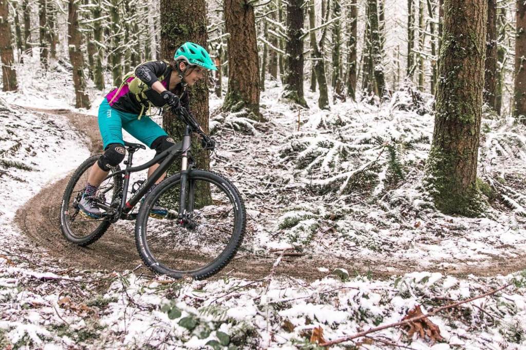Woman cornering on a mountain bike in snow