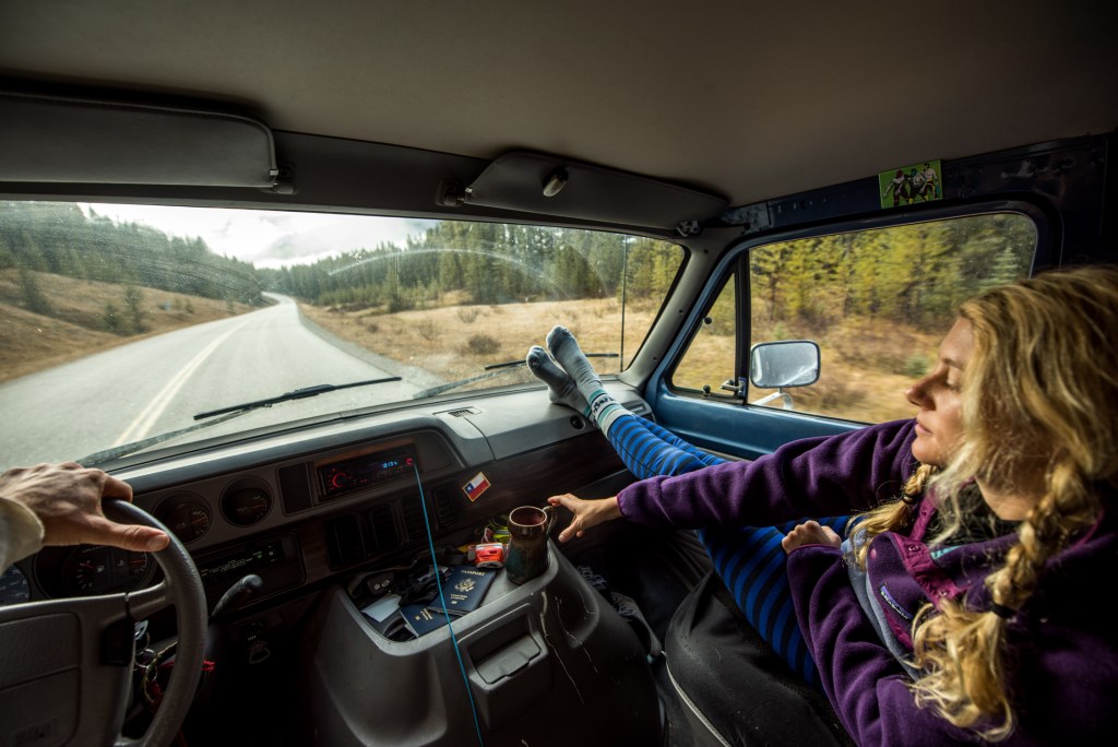 Passenger in car reaches for coffee