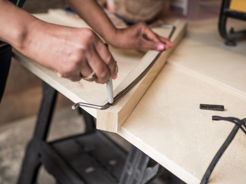 Tracing the curve of the van door onto a piece of wood