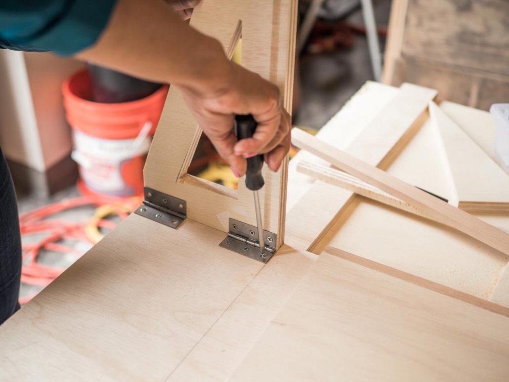 Person installing hinges for the supports