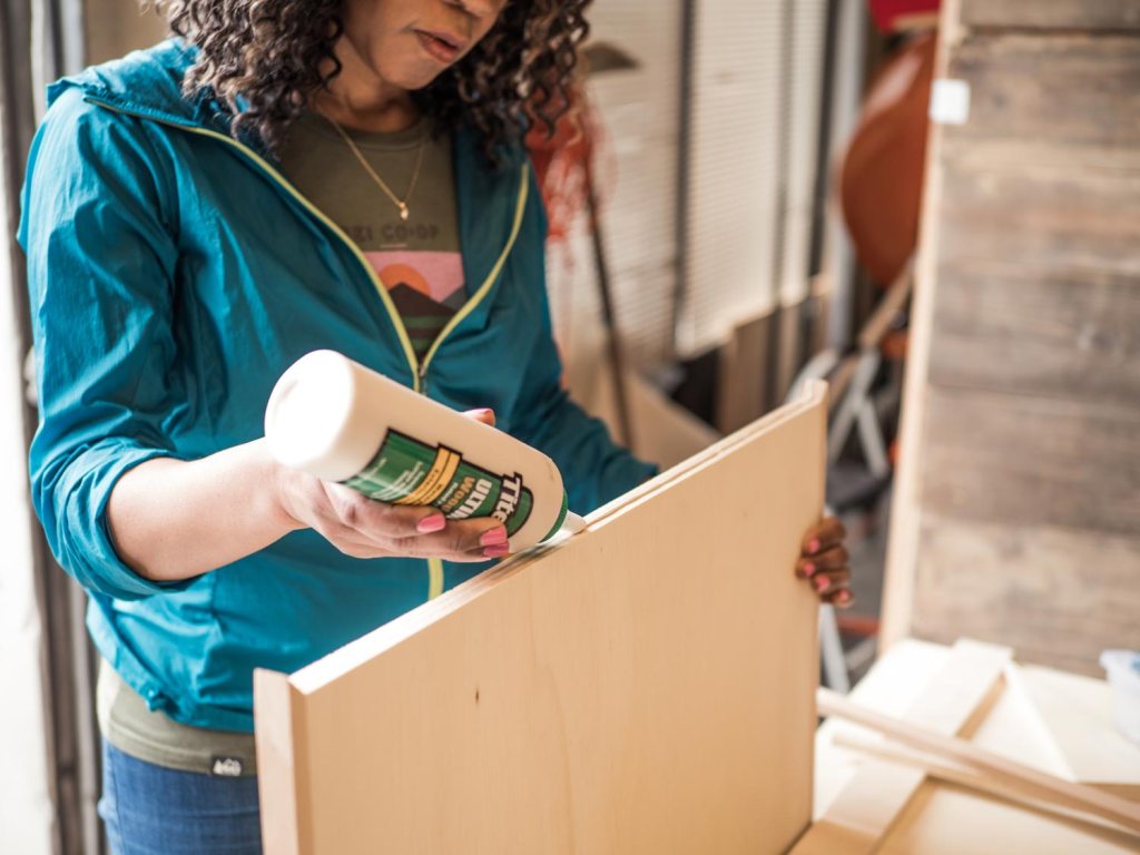 Person applying glue to the outer edges of the van table