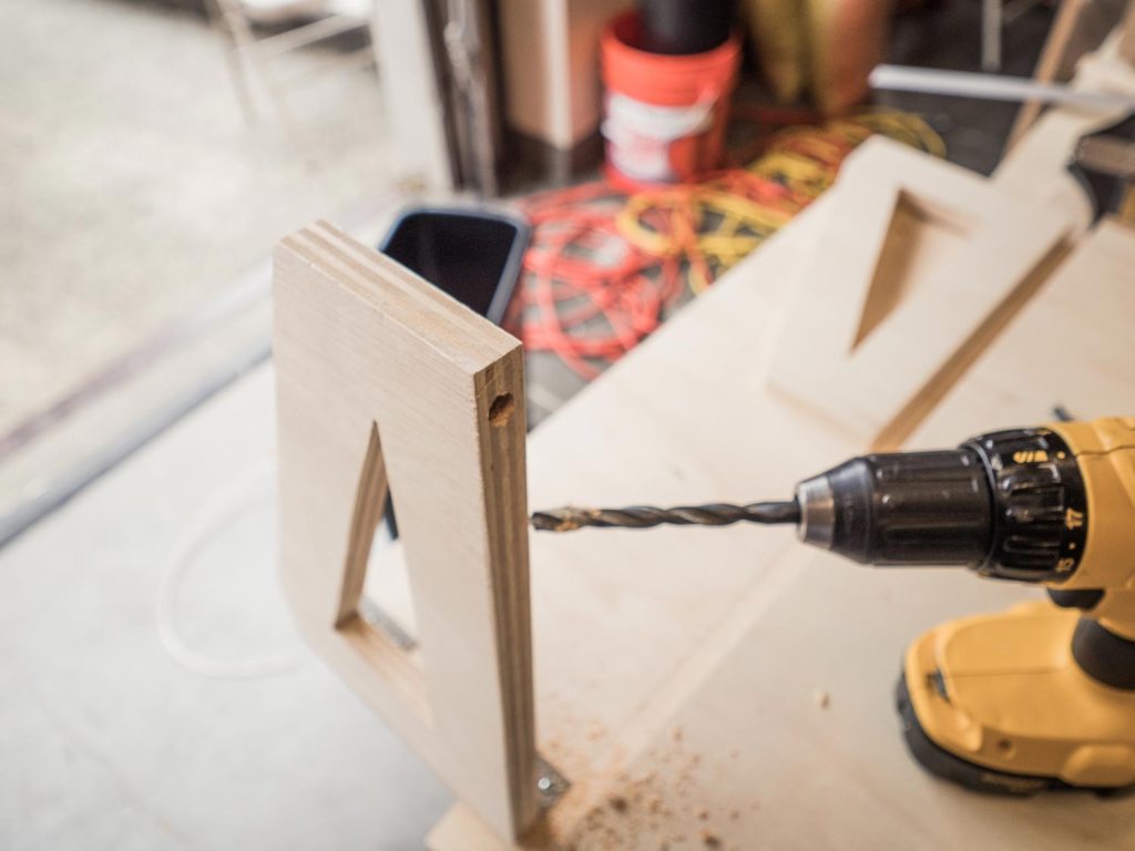 Person drilling a hole into each of the supports 