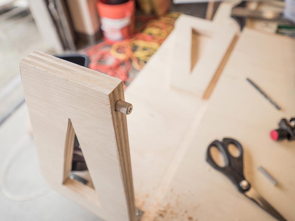 Person screwing in a 2 inch wood screw to the table support