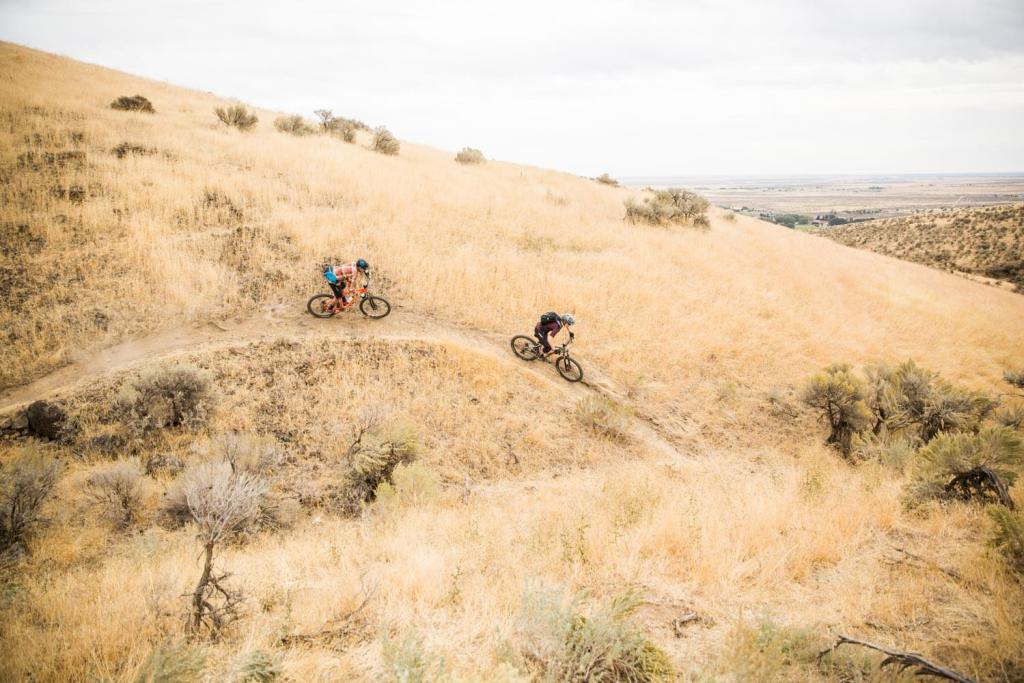 Mountain bike riders navigating around berms.