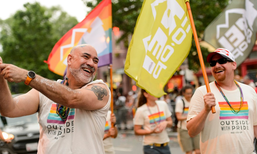 REI Co-op staff members smiled as they waved REI flags at the beginning of the parade.