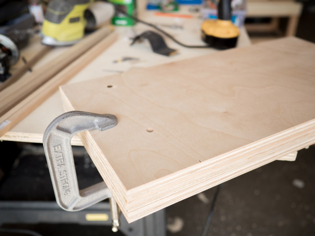 place the drilled backboard on top of the 2 remaining plywood pieces and clamp them together