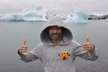 Wim Hof standing in front of an iceberg.