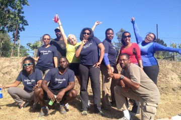 Rue Mapp, founder of Outdoor Afro, standing outside with a group of youth.