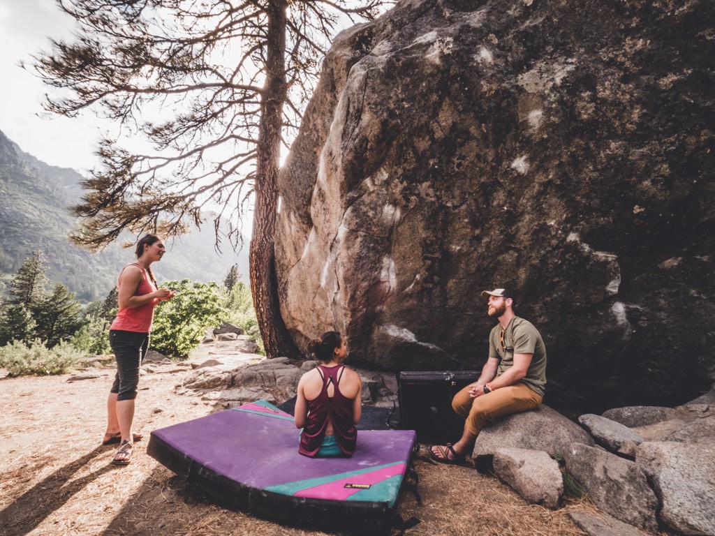 Three climbers rest during a bouldering session.