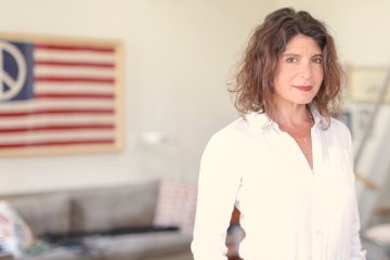 Elizabeth Weil standing in front of her desk, smiling at the camera.