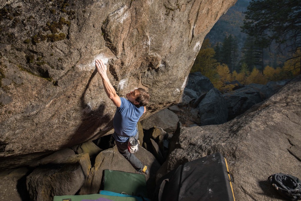 A climber reaches for a hold while bouldering.