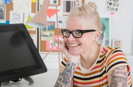 Lisa Congdon sits at her desk in her studio, smiling at the camera.