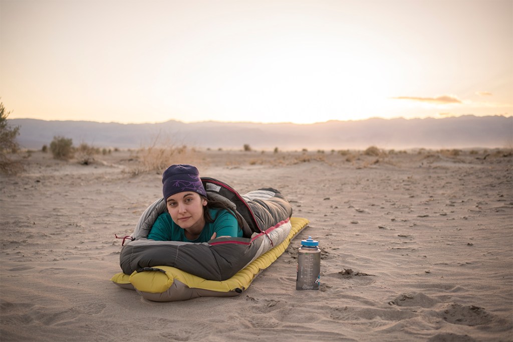 A camper with an REI Adventures trip awakens with the sunrise in Death Valley National Park.
