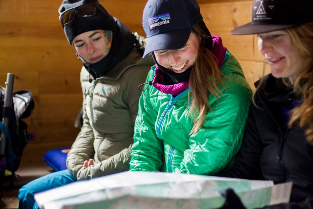 Constant communication is key. After a morning of ski touring these women are reassessing their objective for the day at a hut. 