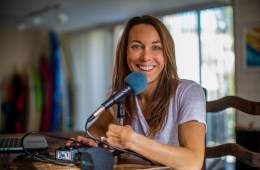 Shelby sitting behind a microphone, smiling at the camera.