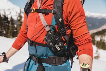 A skier wearing an avalanche beacon.