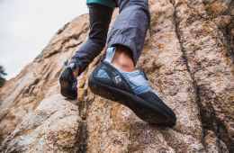 A climber uses their feet to move up an outdoor rock face.