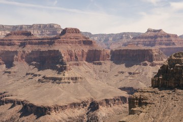 The Grand Canyon's depths are in the foreground, the rock formations behind span as far away into the distance.