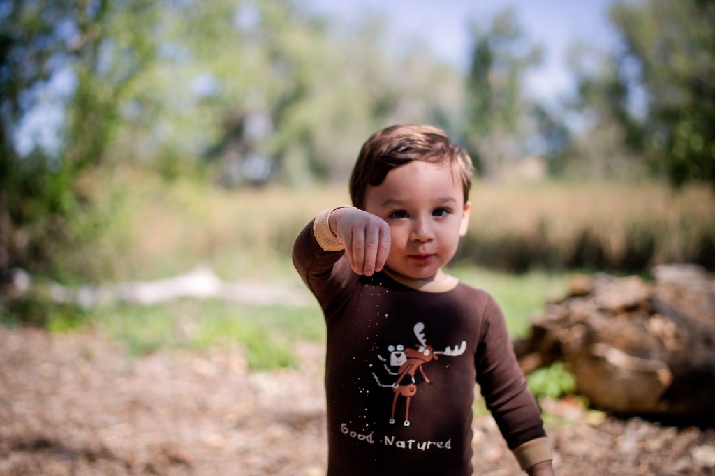 A child plays with dirt in a natural environment