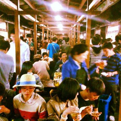 A side-alley of street food buzzes with activity adjacent to Hefang Street in Hangzhou, China.