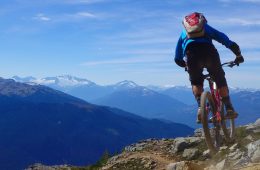 A mountain biker catches some air with the Black Dusk far off in the distance.