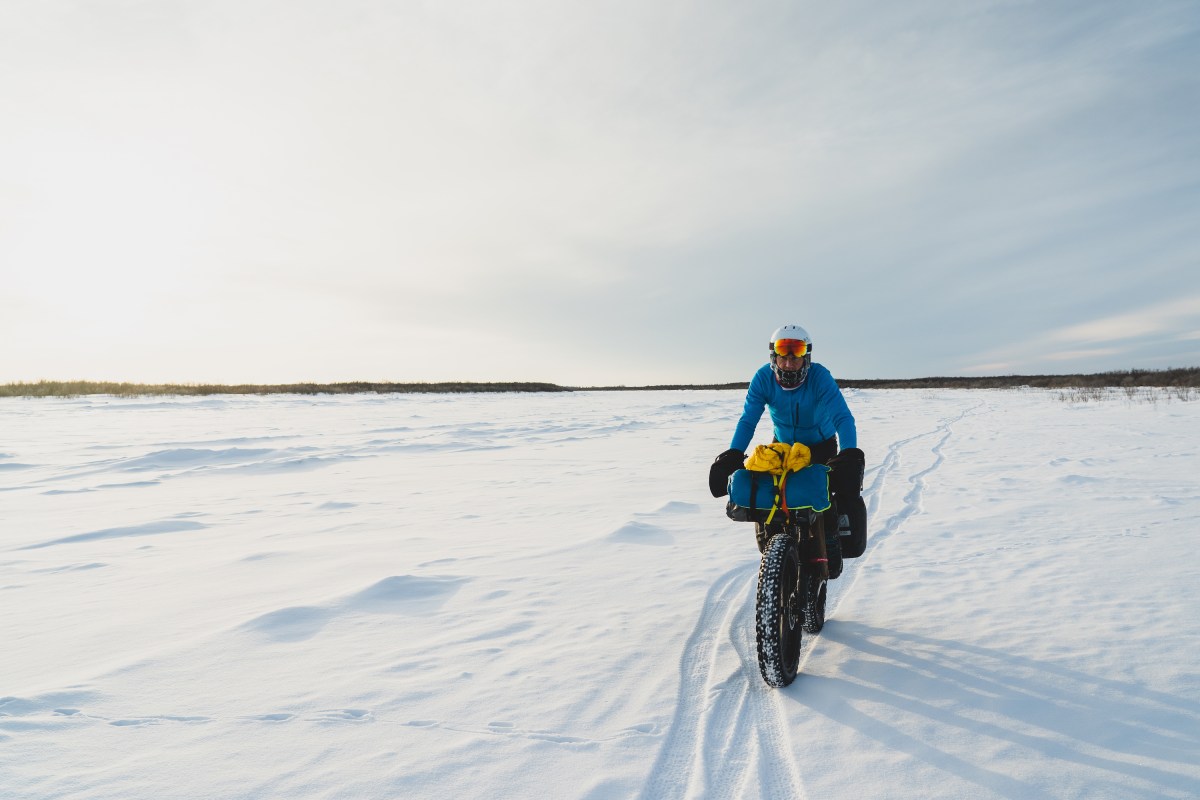 A man on a fat bike in a snowy field.