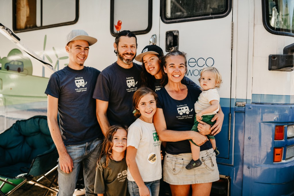 A family poses in matching shirts in front of a recreational vehicle