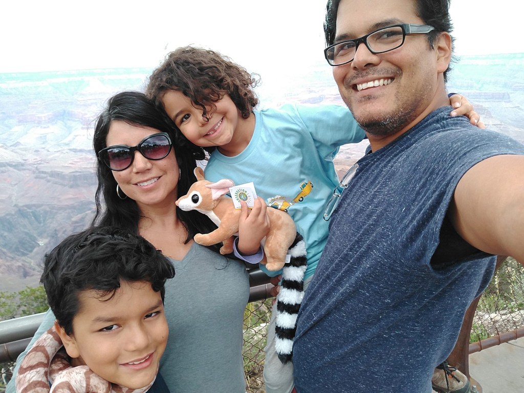 A mom, dad and their two small children pose for a selfie