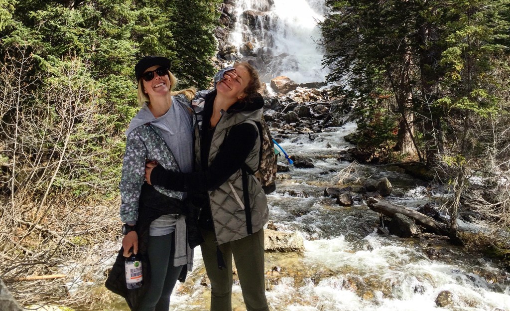 Hadley Hammer and Resi Stiegler hug by a waterfall. 