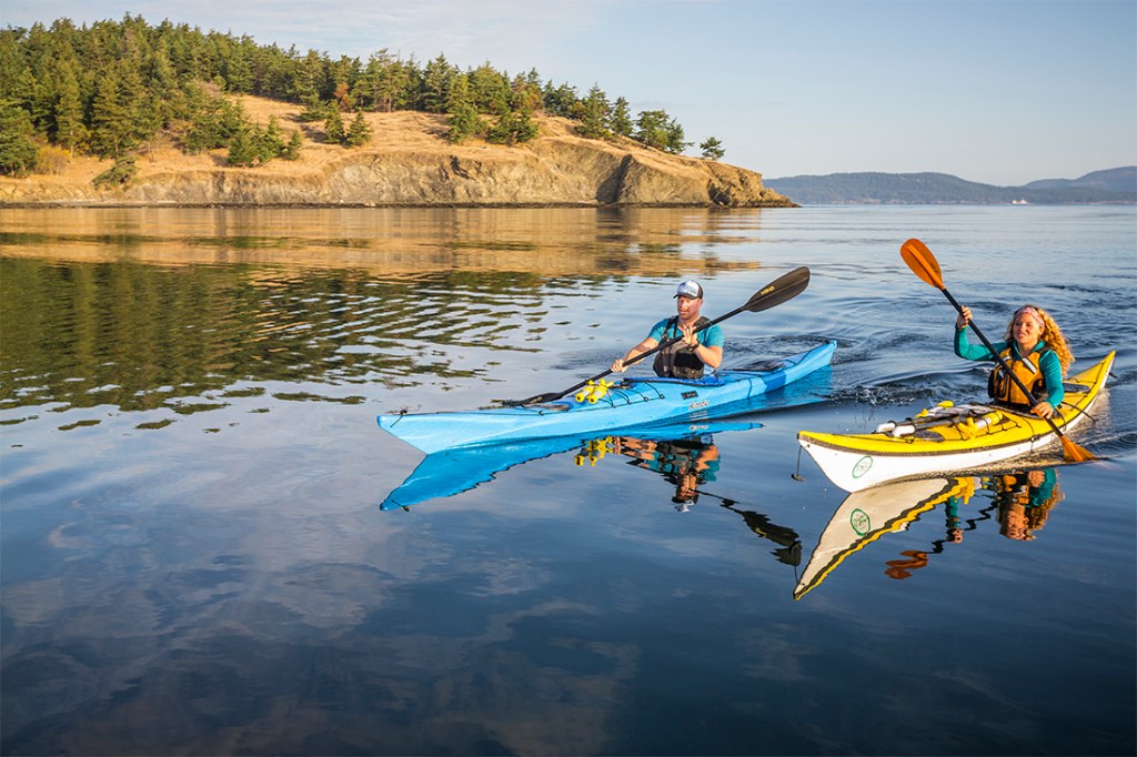 Kayakers navigate the placid waters of the San Juan Islands.