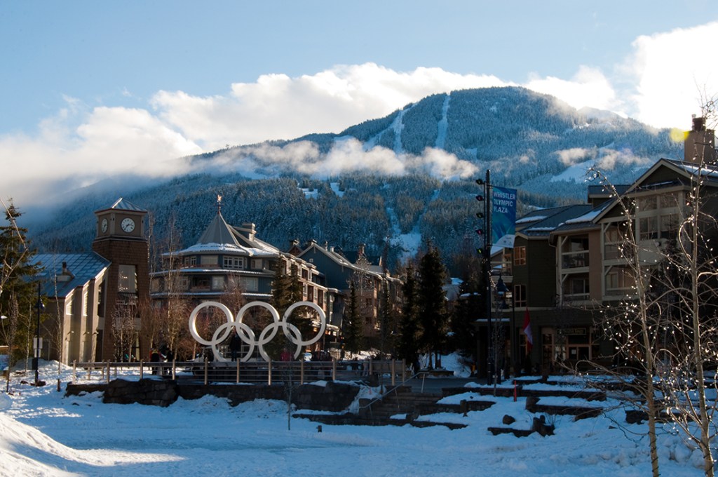 Mountain rise abruptly over a snowy Whistler Village.