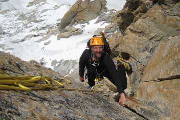 Steve Swenson, in a yellow helmet, looks up while climbing a corner on Latok I in Pakistan's Karakoram range.