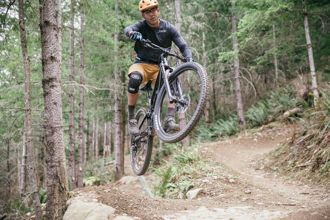 A mountain bike rider catches air off a jump.