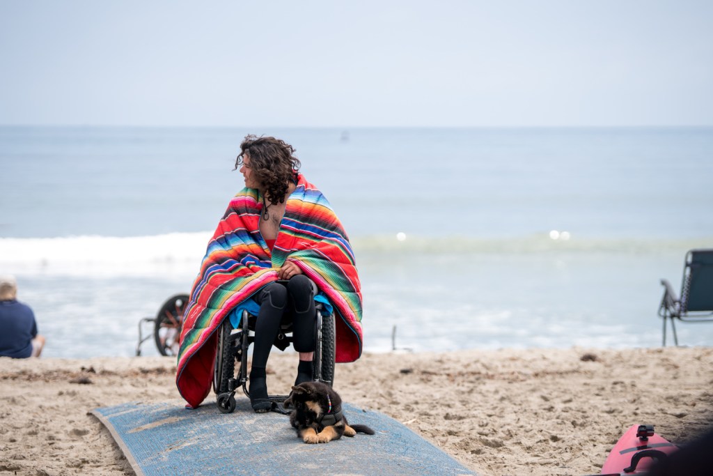 Trevor Kennison sits in his wheelchair on the beach after a surf lesson.