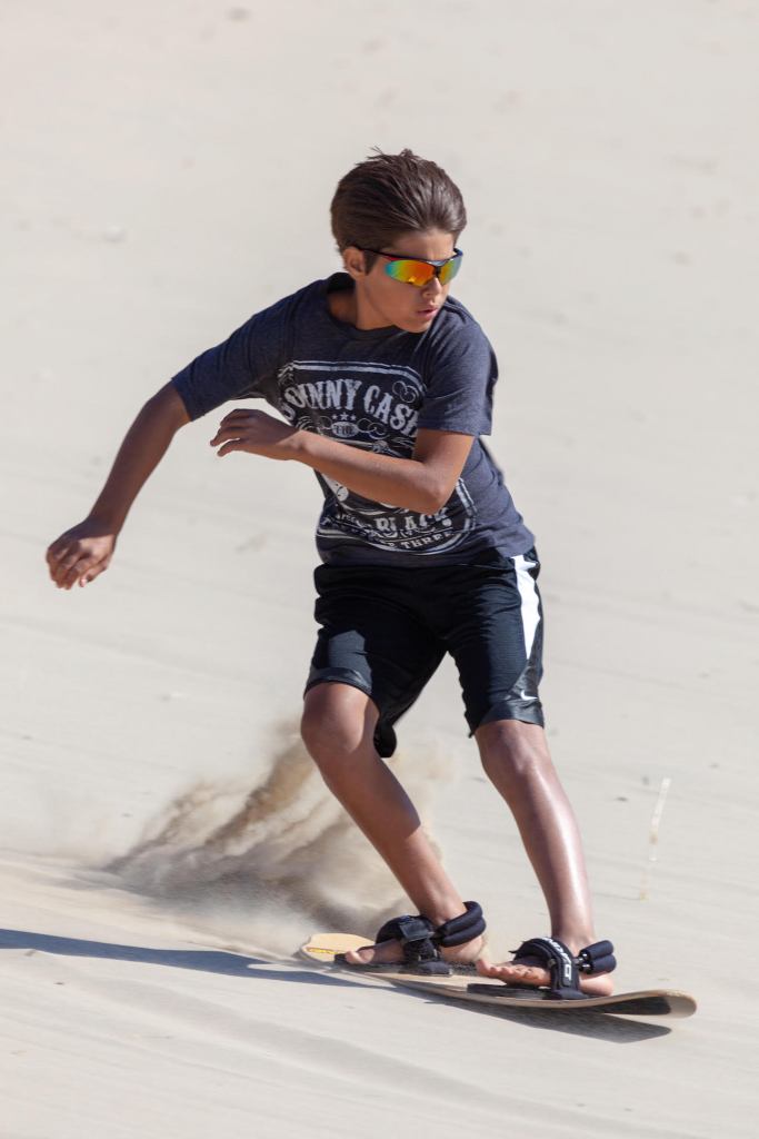 A sandboarder at Oregon's Sand Master Park slides down sand.